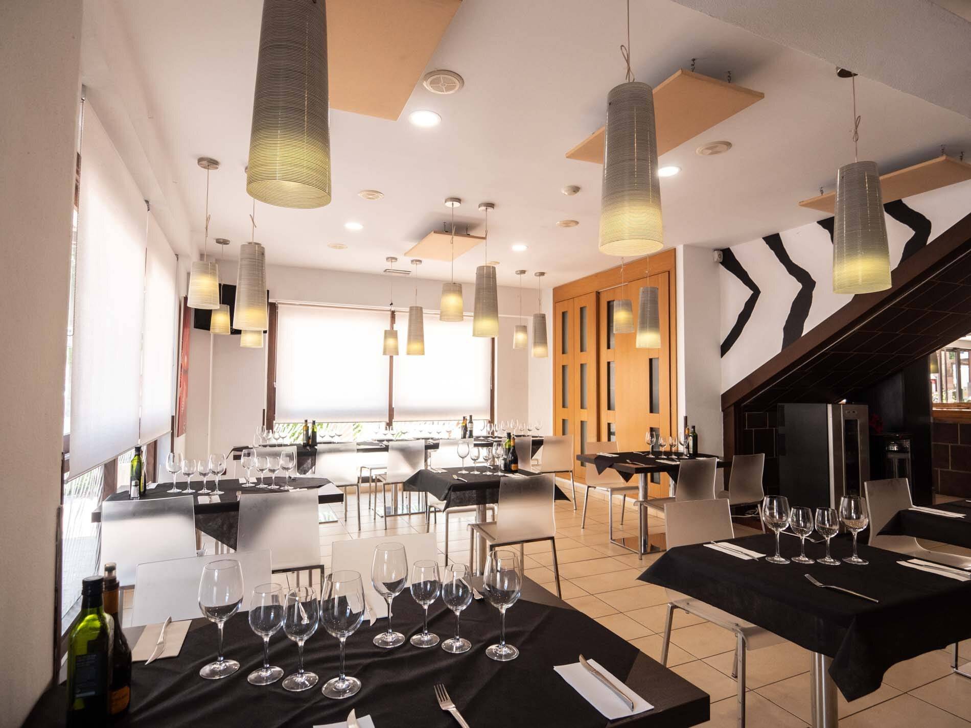 Comedor interior de Zebra Steak & Grill, con las mesas montadas y la pared de rayas de cebra