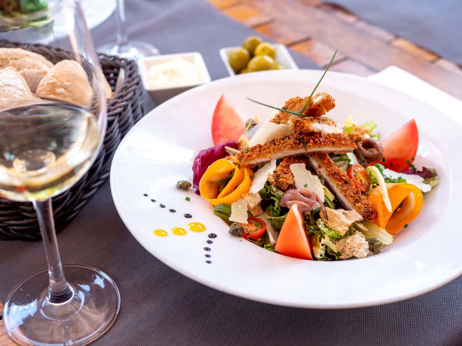 Ensalada César con pollo crujiente, lascas de parmesano y anchoas
